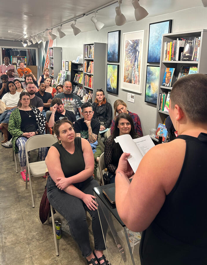 Evan reading to an audience of people at the book launch for Recurring Characters