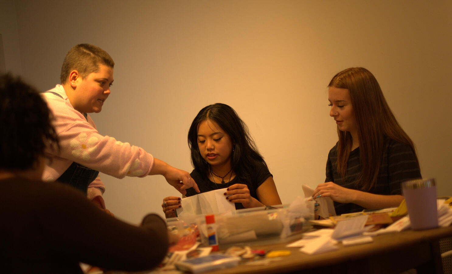 Untitled Evan giving hands-on instruction at a zine making workshop